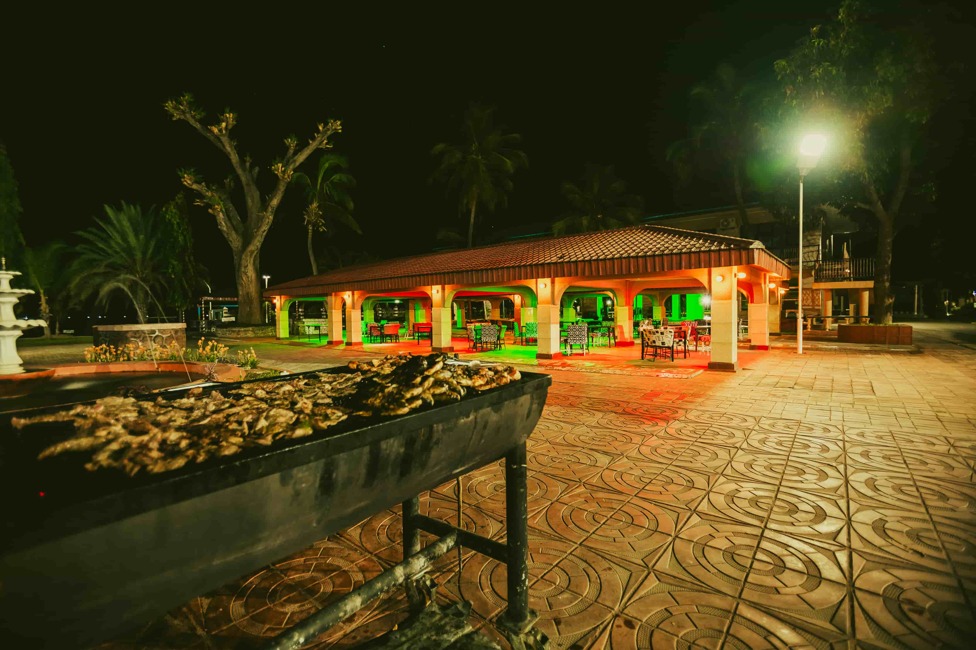 close up of grill with meat outside restaurant at night